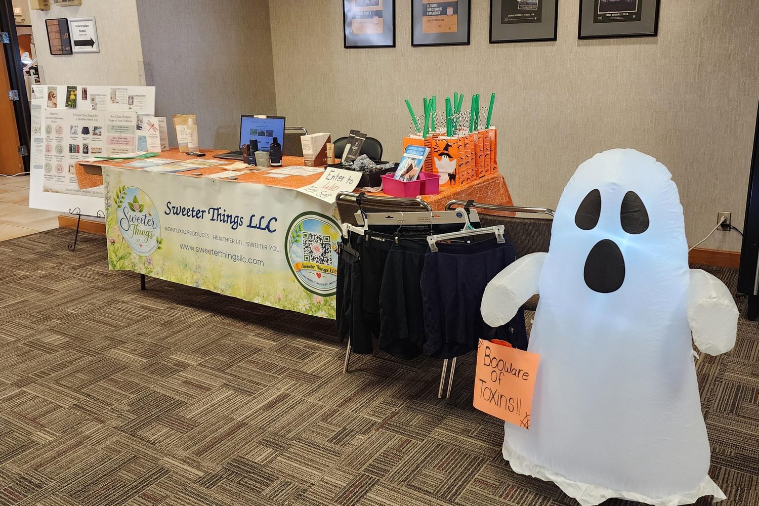 The Sweeter Things LLC booth at the Wellness Expo with a friendly inflatable ghost holding a sign that reads Booware of Toxins
